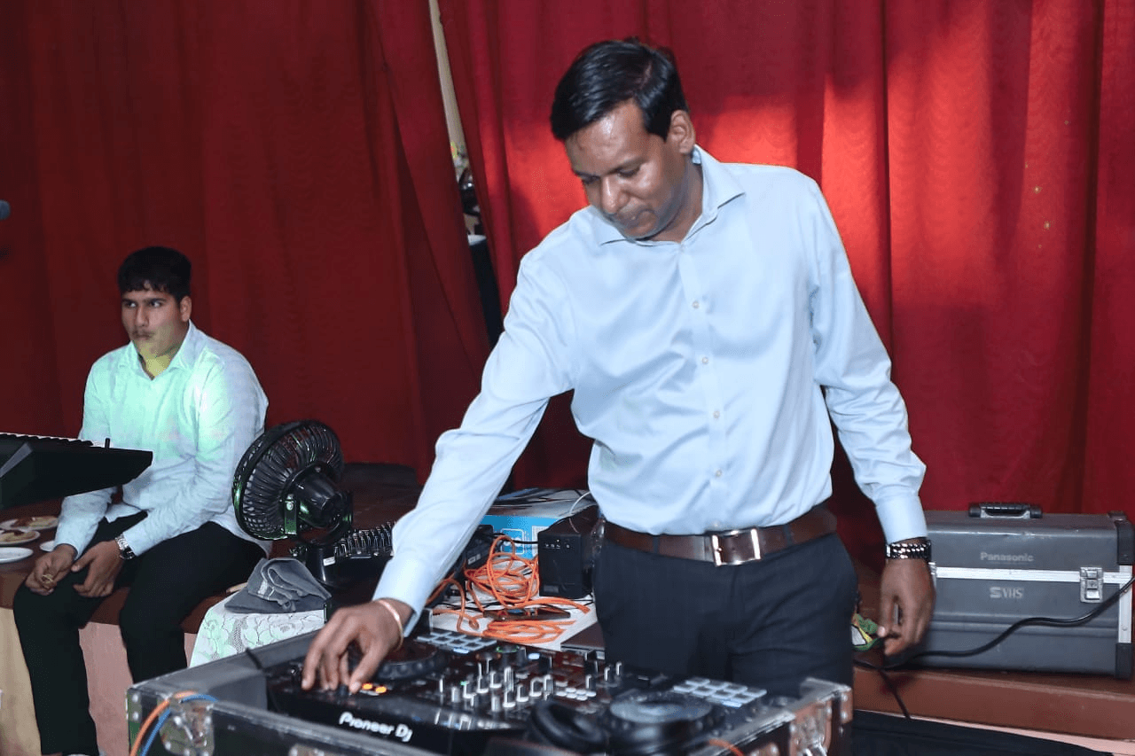 DJ Dolphin working the decks at an indoor reception